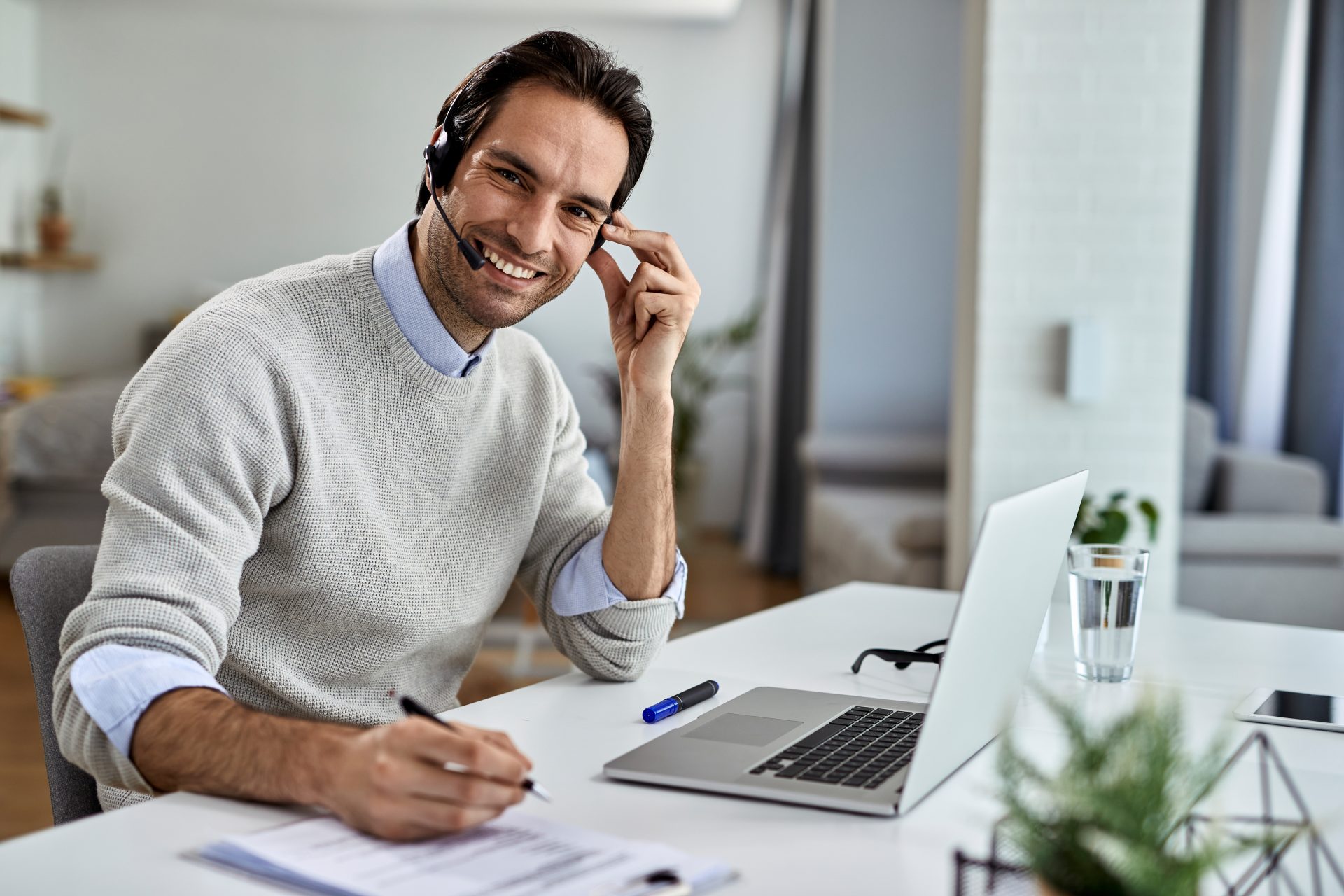 happy businessman working on a computer at home and looking at c